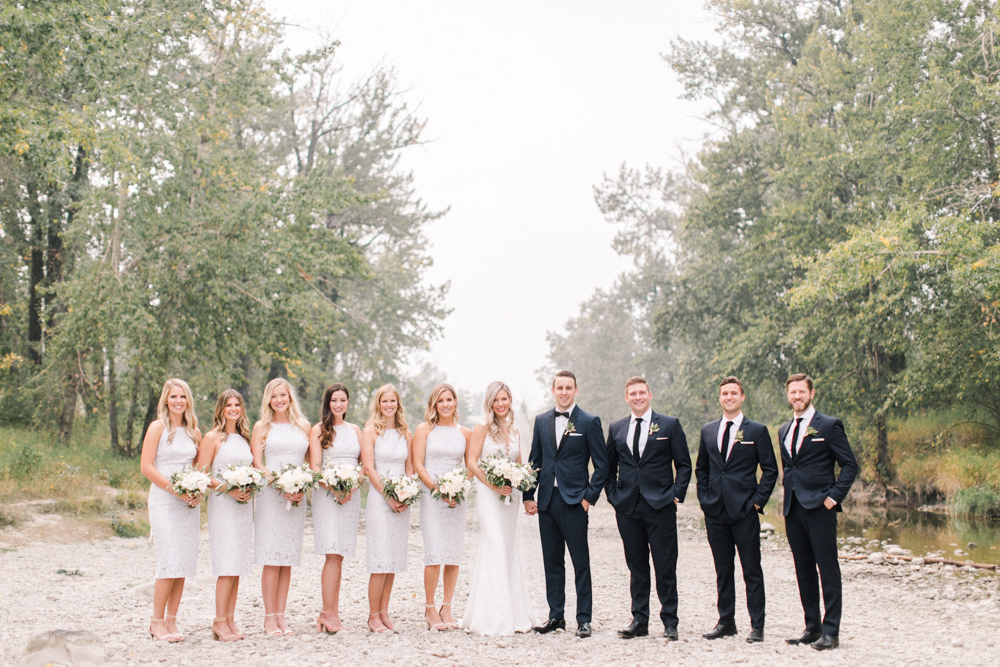 wide angle shot of entire wedding bridal party portrait  at fish creek park in Calgary at the lake house in Calgary