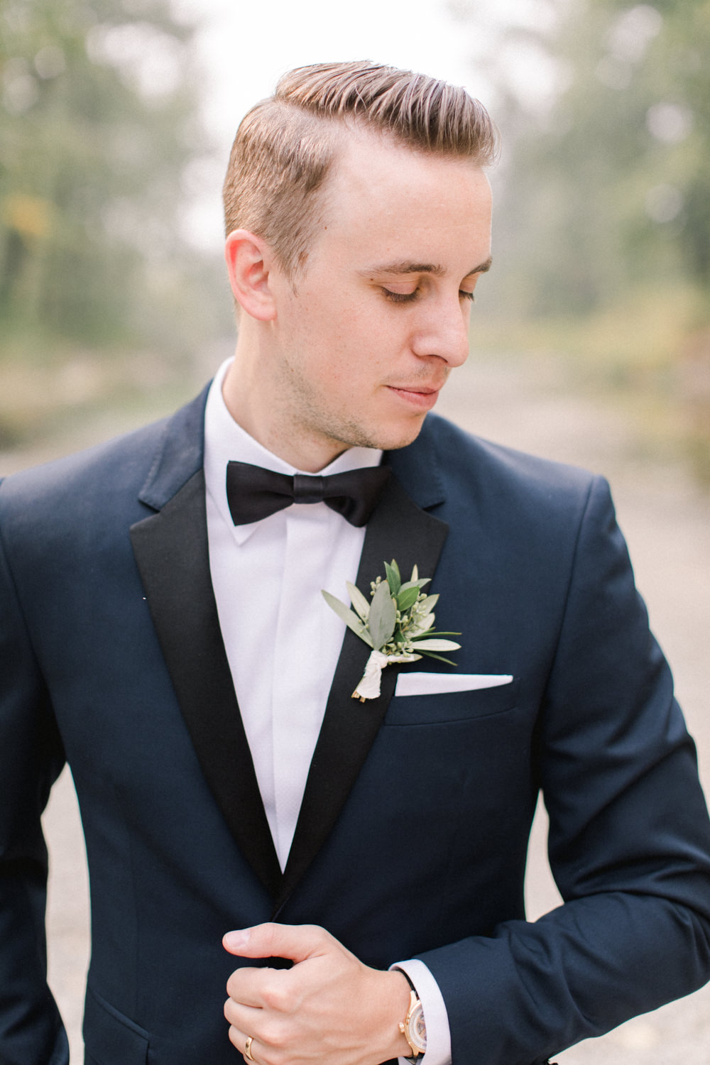 portrait of groom at fish creek park in Calgary at the lake house in Calgary