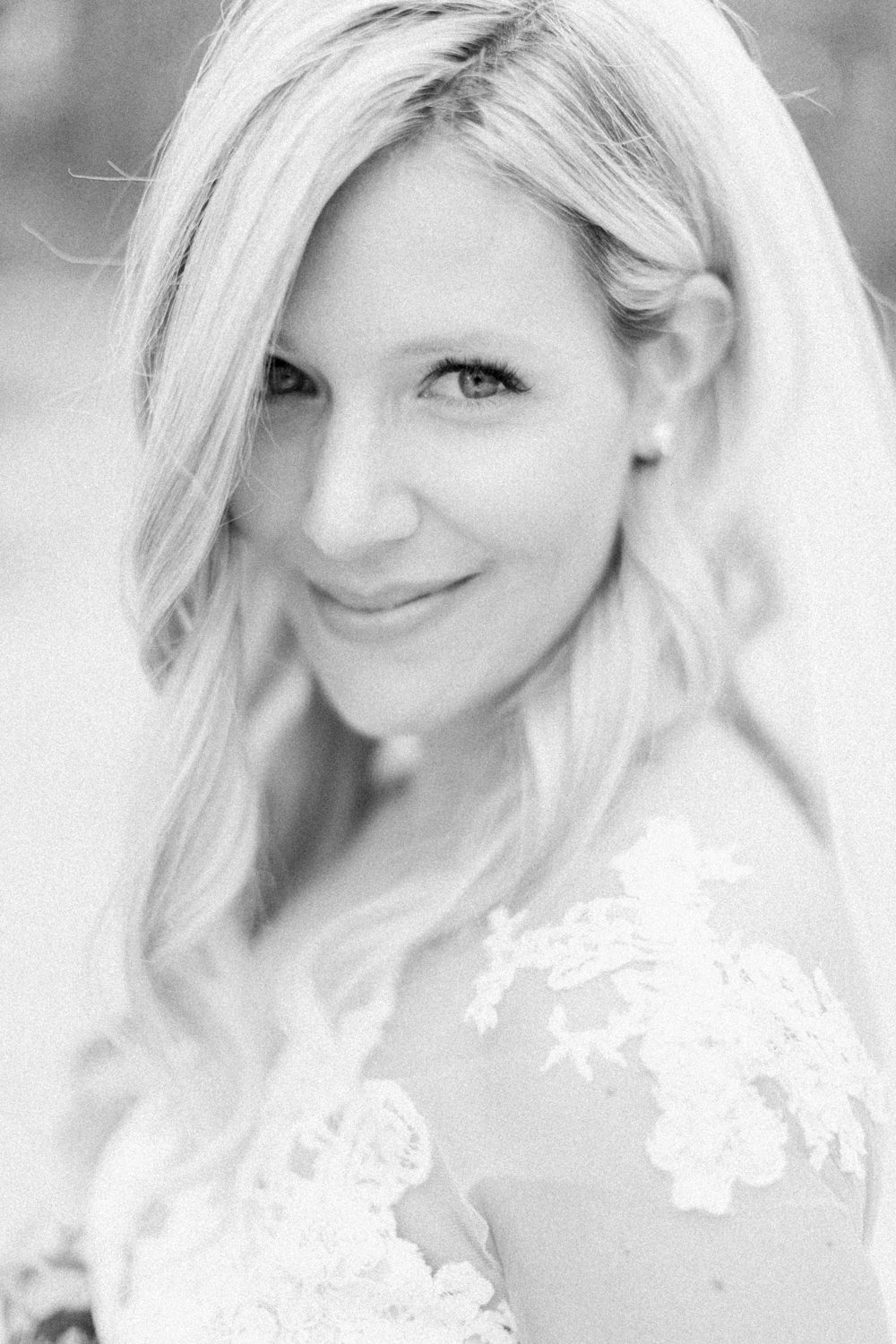 portrait of the bride smiling at the camera at fish creek park in Calgary at the lake house in Calgary