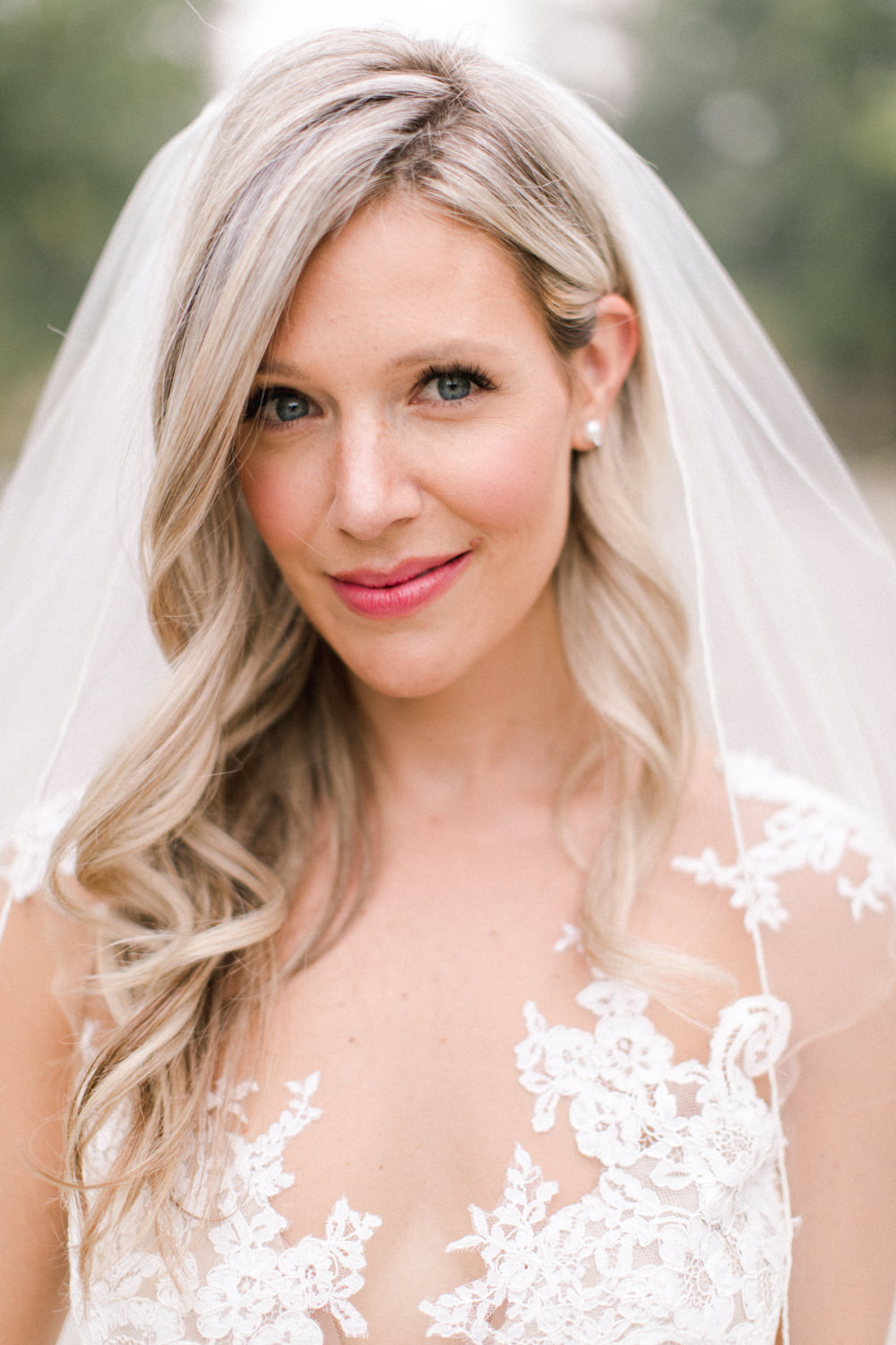 close up portrait of the bride bride with wedding bouquet at fish creek park in Calgary at the lake house in Calgary
