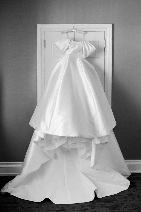 back and white photo of wedding gown hanging on door frame at the Calgary Fairmont Palliser Hotel