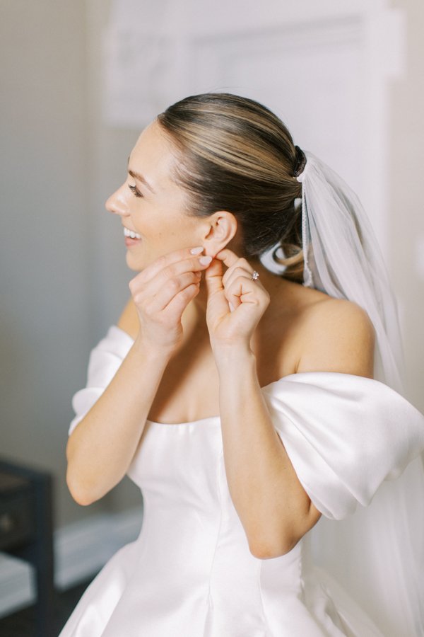 photo of bride putting in earrings at the Calgary Fairmont Palliser Hotel