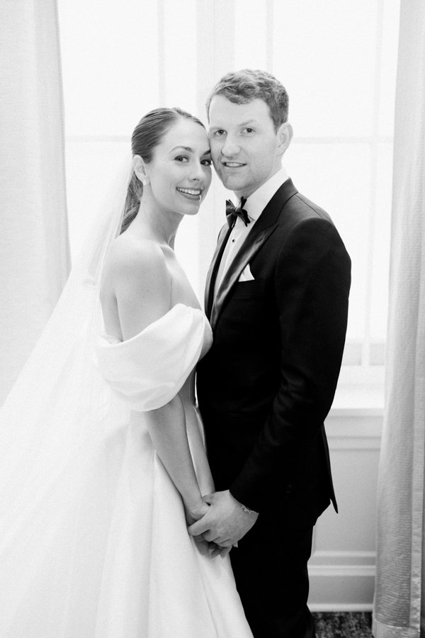 black and white shot of bride and groom holding handsat the Calgary Fairmont Palliser Hotel