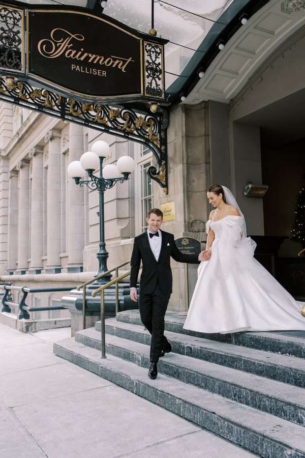 wide shot of bride and groom exiting the main hotel entrance the Calgary Fairmont Palliser Hotel