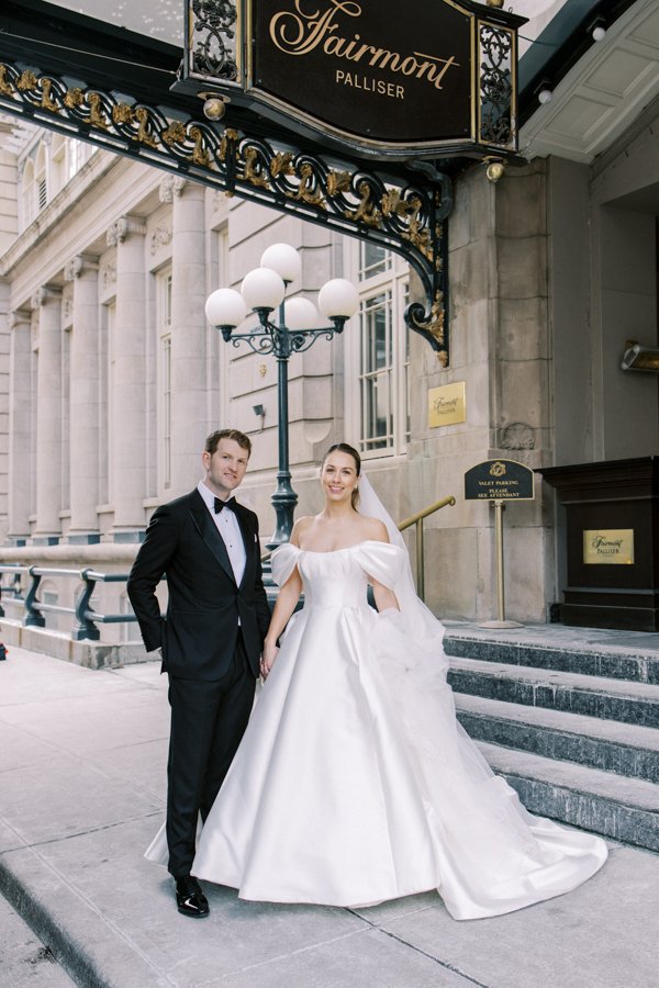 wide shot of bride and groom standing in front of home sign at the Calgary Fairmont Palliser Hotel