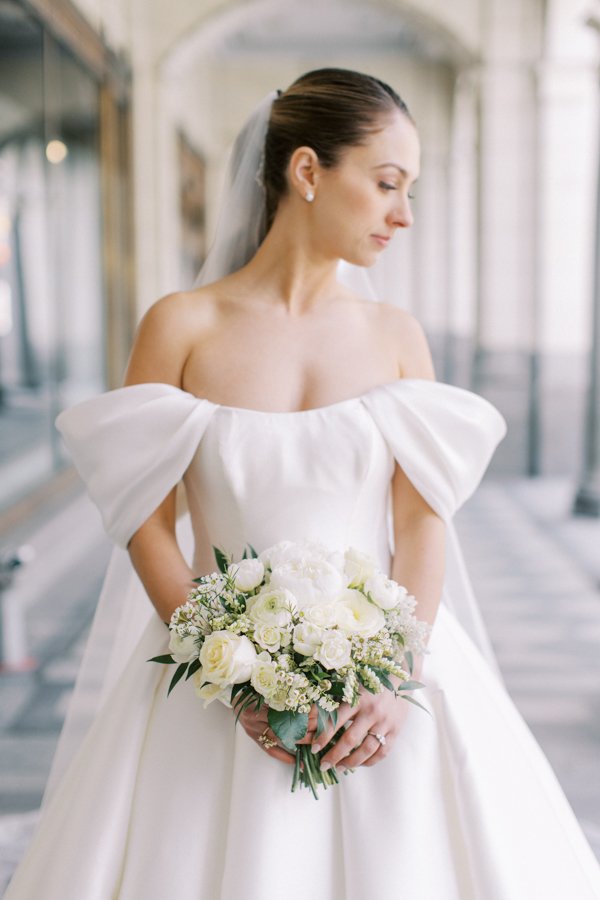 close portrait of the bride with flowers standing at the Calgary Fairmont Palliser Hotel