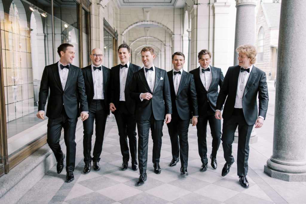 portrait of the groom with grooms men walking at the Calgary Fairmont Palliser Hotel