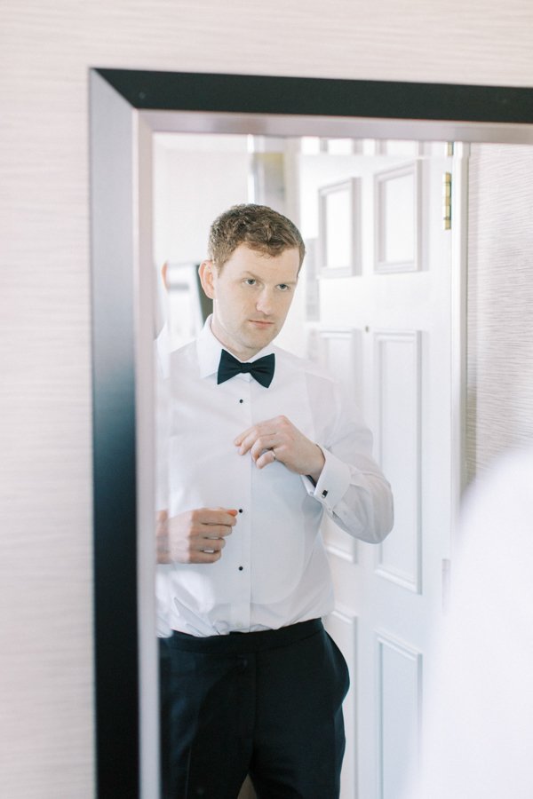 groom getting ready infront of mirror at the Calgary Fairmont Palliser Hotel