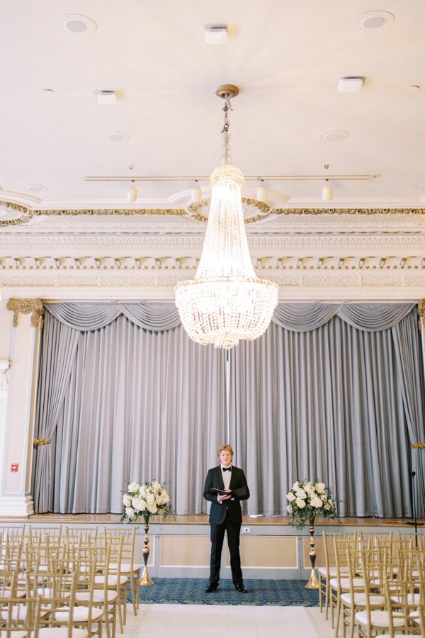 wedding ceremony set up with gold chairs and officiant standing in the centre the Crystal Ballroom at the Calgary Fairmont Palliser Hotel