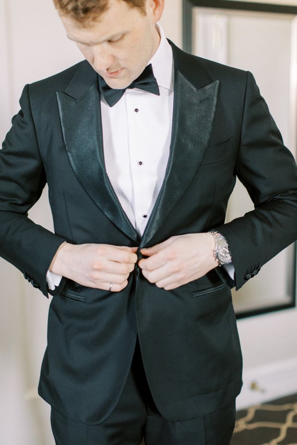 groom buttoning suit jacket at the Calgary Fairmont Palliser Hotel