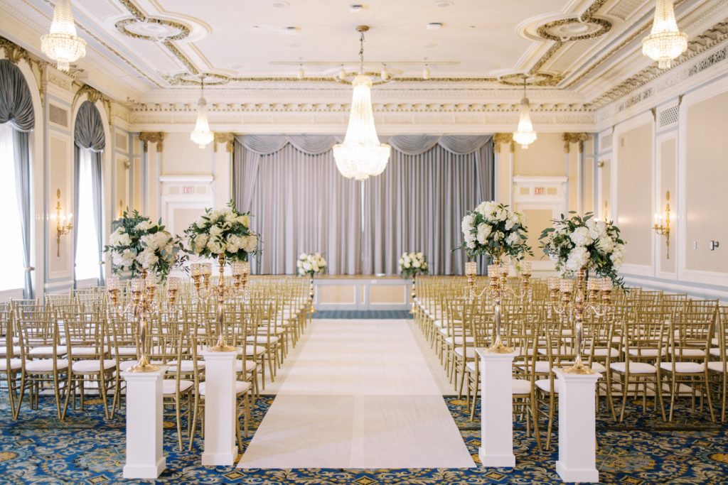 wide shot of wedding ceremony set up with gold chairs the Crystal Ballroom at the Calgary Fairmont Palliser Hotel